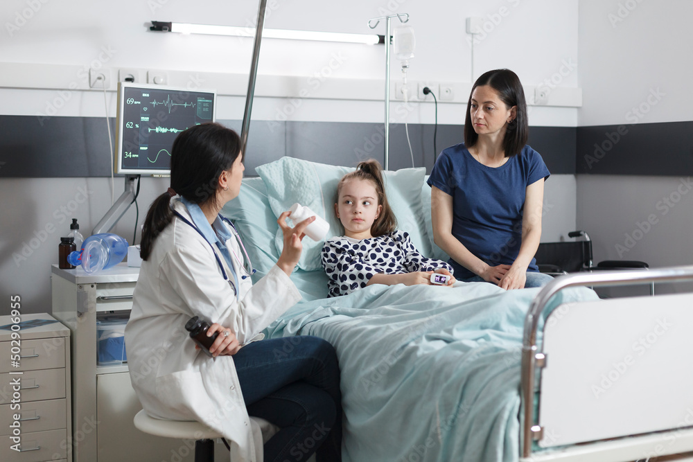 Clinic pediatric specialist recommending ill patient girl right medicine for illness remission. Hospital pediatrist specialist talking with attentive mother about illness treatment. Clinic pediatric specialist recommending ill patient girl right medicine for illness remission. Hospital pediatrist specialist talking with attentive mother about illness treatment.