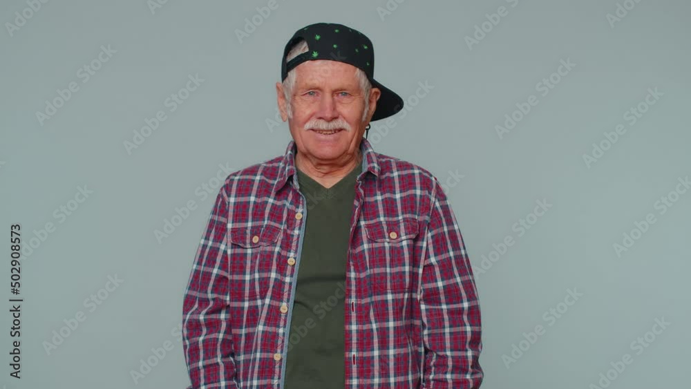 Portrait of seductive cheerful stylish man in shirt taking off sunglasses, charming smile. People emotions concept. Senior lovely mature grandfather posing isolated alone on gray studio background Portrait of seductive cheerful stylish man in shirt taking off sunglasses, charming smile. People emotions concept. Senior lovely mature grandfather posing isolated alone on gray studio background