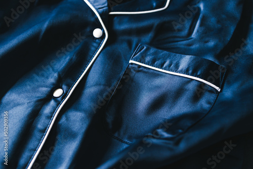 luxurious navy blue silk or satin tailored pyjama detail, fabric close-up with soft wrinkles photo