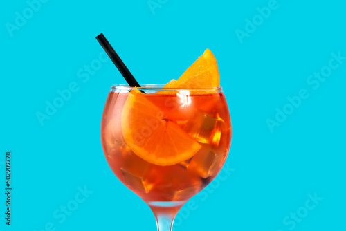 Glass of aperol spritz cocktail on blue background
