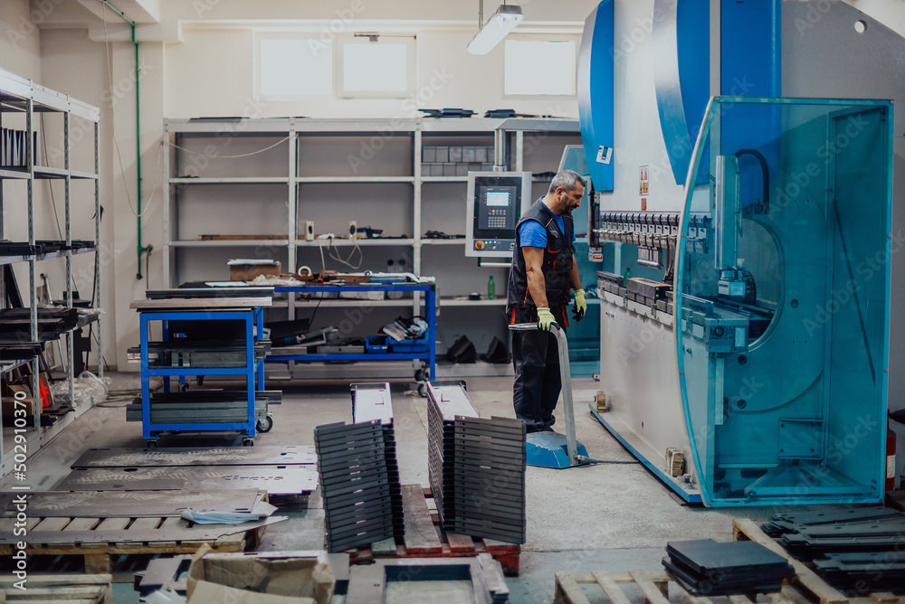 A smart factory worker or engineer makes machines in a production workshop. The concept of industry and engineering. Selective focus A smart factory worker or engineer makes machines in a production workshop. The concept of industry and engineering. Selective focus