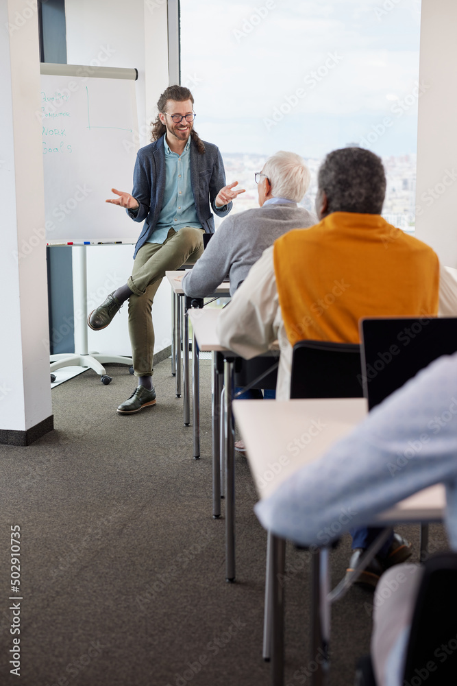 Young educator teaching a multicultural group of senior students in the classroom. Young educator teaching a multicultural group of senior students in the classroom.