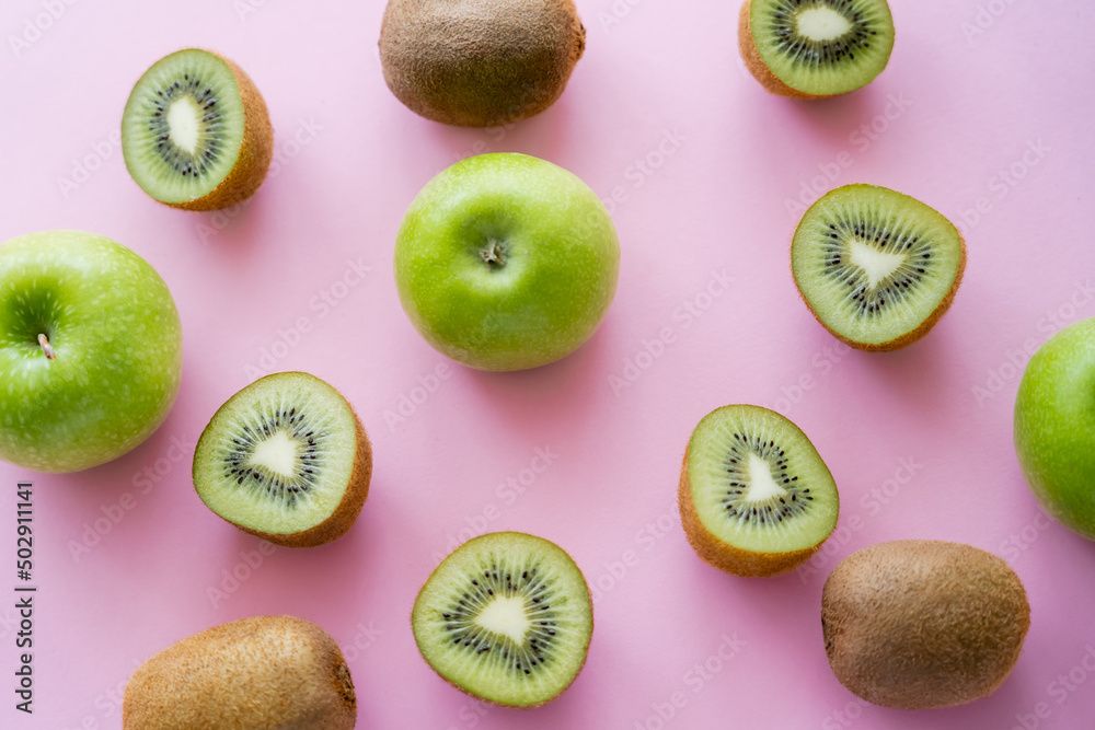 Fototapeta premium top view of green apples and kiwi on pink.
