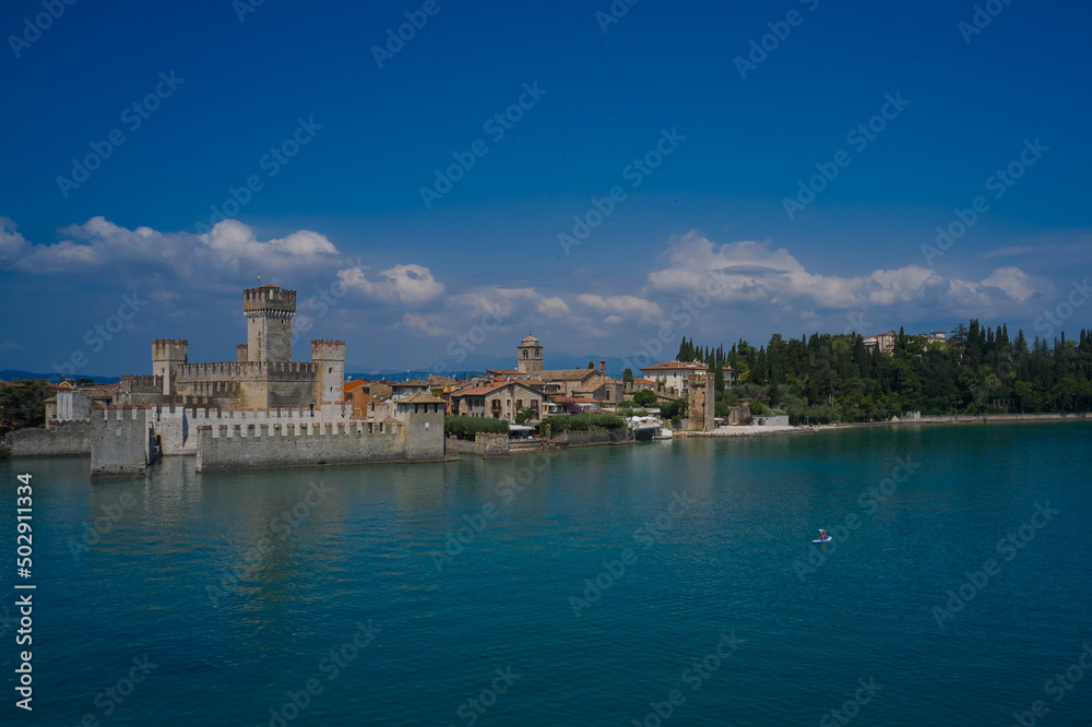 Sirmione, Lake Garda, Italy. The man on the sup board near the walls of the main castle of Sirmione
