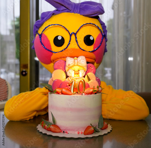 The duck is behind the cake