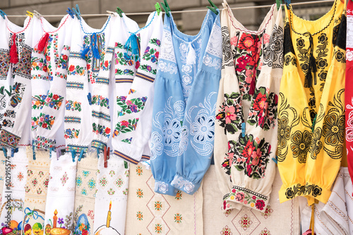 Ethnic ukrainian traditional embroidered shirts, vyshyvanka - traditional embroidered clothes on flea market or national festival. Vintage goods on flea market. Symbol of Ukrainian culture © Iryna Mylinska