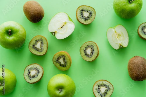 Fototapeta Naklejka Na Ścianę i Meble -  top view of tasty kiwi and apples on green.
