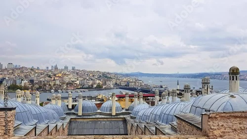 Panoramic view over The Golden Horn bay, the Bosporus inlet, Istanbul, Turkey, over Suleymaniye Mosque. Daylight shot, cloudy weather. Suleyman the Magnificent historical building. photo