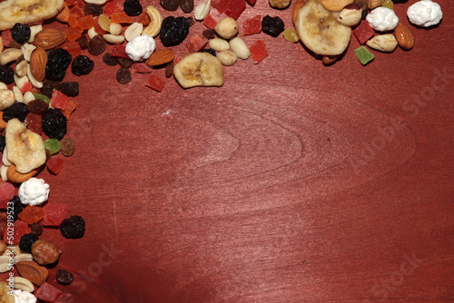 dried fruits and nuts on a wooden table, incomplete frame of their dried fruits