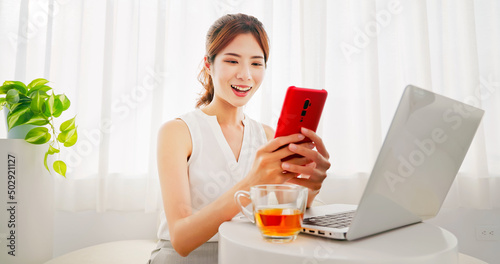 woman uses laptop and phone