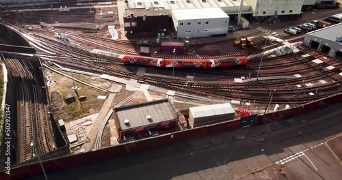 Glasgow Subway train over ground entering service depot in Govan, aerial shot 4k