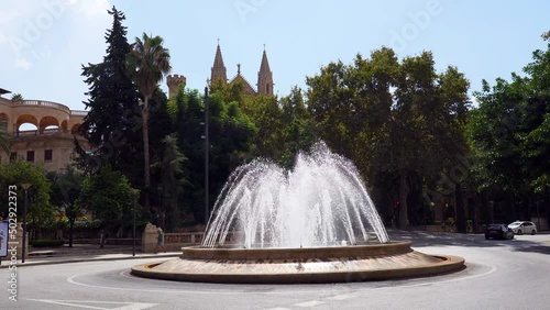 Still shot of the Fountain at Placa De La Reina (Reina Square) with the cathedral spires in the background - Palma de Mallorca, Spain
