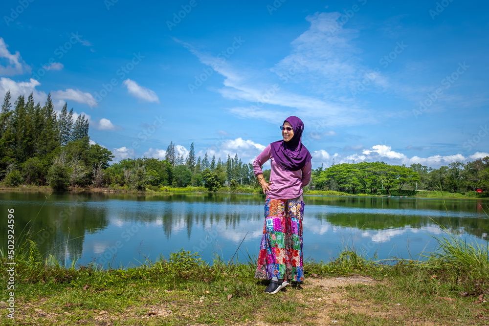 Islam Woman with sunglasses standing near lake at Liwong, Songkhla, Thailand Islam Woman with sunglasses standing near lake at Liwong, Songkhla, Thailand