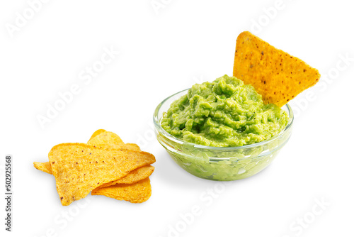 Fresh homemade vegetarian guacamole mexican dip, sauce or salad made of mashed ripe raw avocado served in glass bowl with crispy tortilla chips or nachos as healthy snack isolated on white background photo