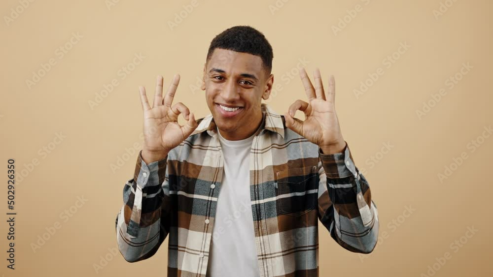 Positive approval. Young playful black guy dancing and gesturing OK with both hands, folding arms and smiling to camera Positive approval. Young playful black guy dancing and gesturing OK with both hands, folding arms and smiling to camera