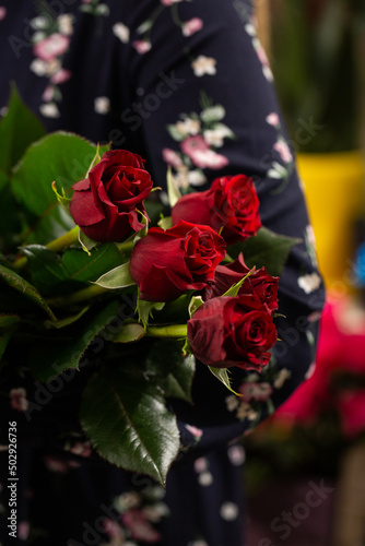 Bouquet of red roses. Gift idea for valentine's day. Florist woman holding a fresh bouquet. © MONIUK ANDRII