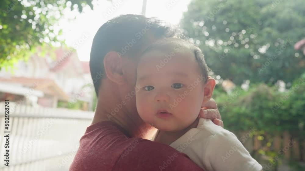Family Protection. Loving father holds on a cute asian baby, serious lovely infant looking staring at camera, close up face portrait view. Concept of parental protection, family ties, babyhood Family Protection. Loving father holds on a cute asian baby, serious lovely infant looking staring at camera, close up face portrait view. Concept of parental protection, family ties, babyhood