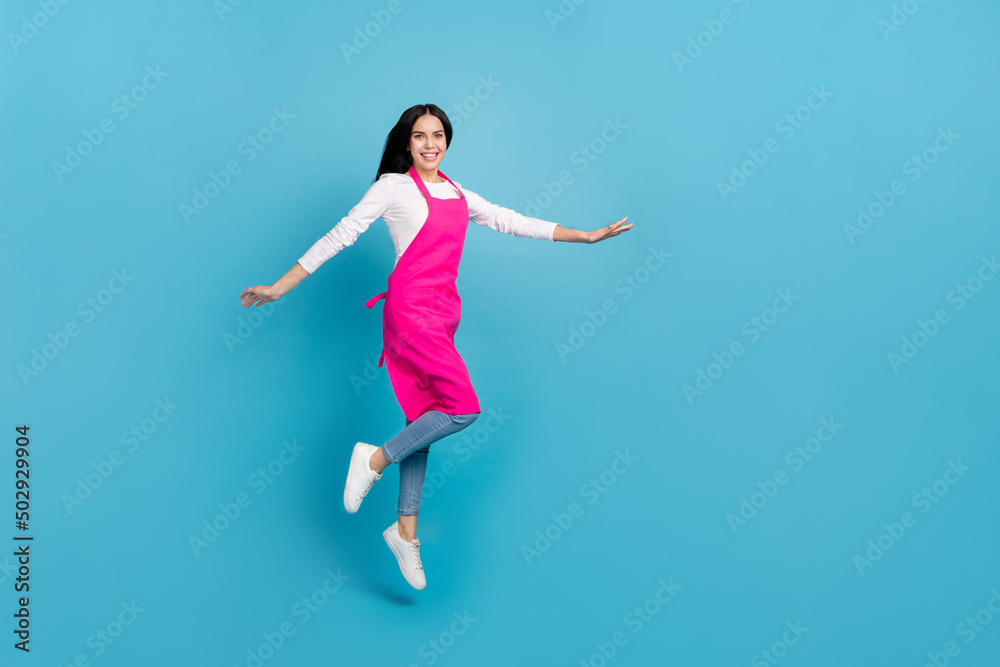 Full length body size view of attractive cheery girl hairdresser jumping isolated over bright blue color background Full length body size view of attractive cheery girl hairdresser jumping isolated over bright blue color background