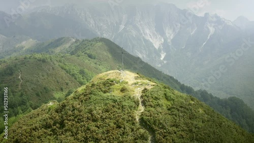 Path to faith and spirituality with cross on hilltop in magnificent apuane landscape