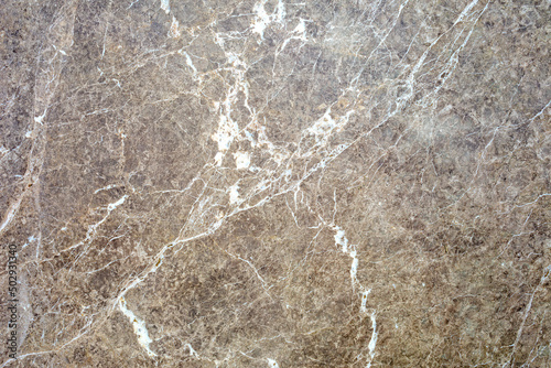 Polished brown marble surface with white chaotic stripes as background, texture, pattern. photo
