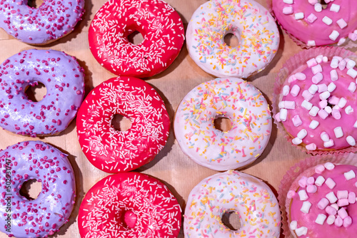 Donuts are covered with colorful icing and sprinkled with marshmallows, colorful and confectionery decorations.
