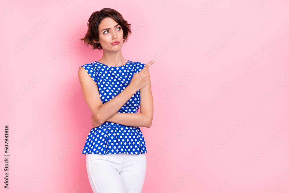 Photo of sad young brunette lady look empty space wear blue top jeans isolated on pink color background Photo of sad young brunette lady look empty space wear blue top jeans isolated on pink color background
