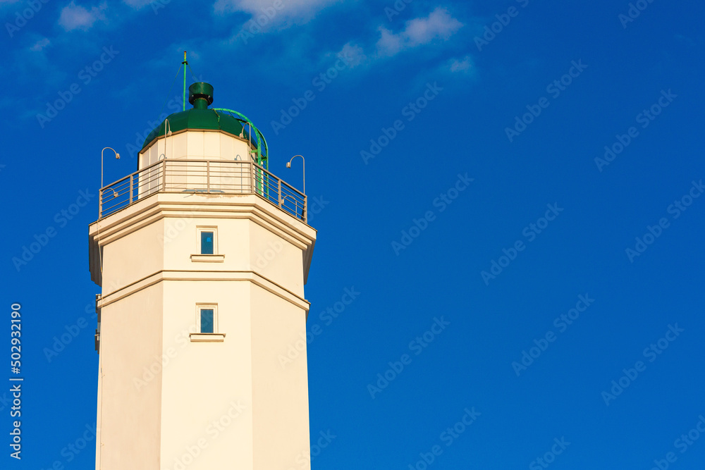 A beautiful white lighthouse against a blue sky.