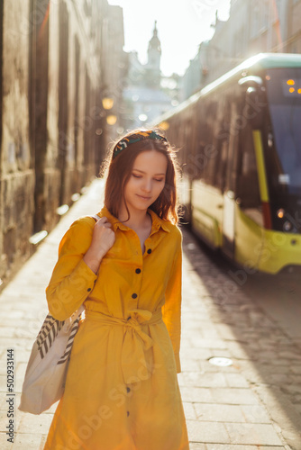 Stylish girl in summer outfit walk on old city street