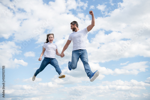 happy father and daughter jump in sky