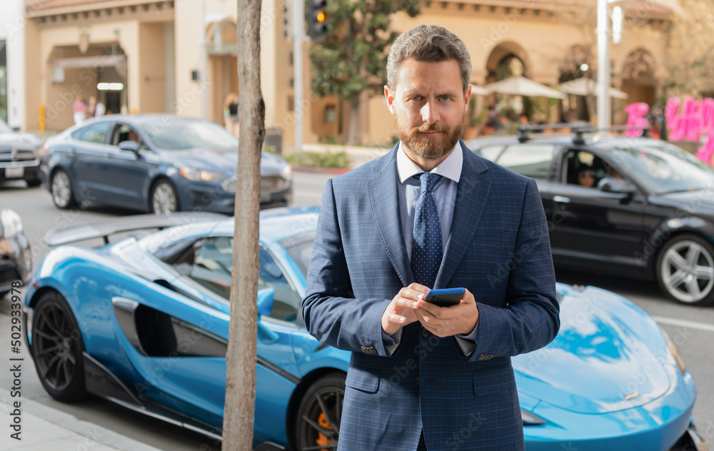 businessman chat on phone next to luxury car. copy space