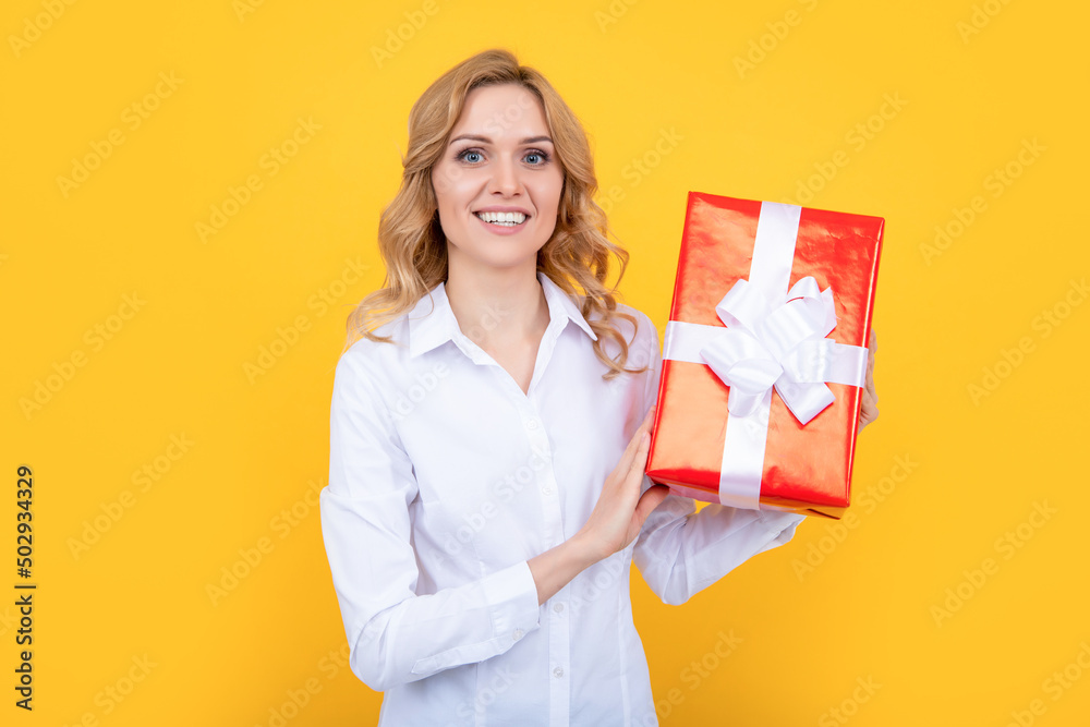 cheerful woman hold big present box on yellow background cheerful woman hold big present box on yellow background