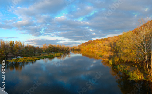 Sunrise in autumn by the lake, lake in the backlight of the rising sun, park in autumn and autumn leave in the sunlight in the morning, colorful leaves on the water, trees in the autumn by the water photo