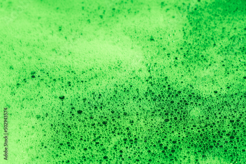 background green foamy water close-up. abstract bubbles in white color