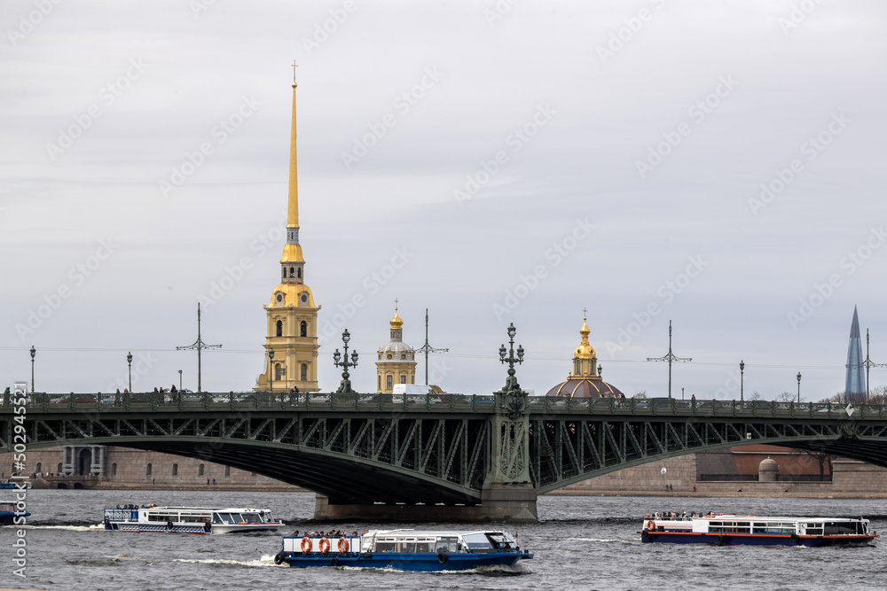 The Neva river in St. Petersburg with a floating pleasure boat overlooking the Trinity Bridge and the Peter and Paul Fortress