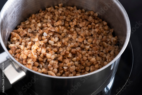 Boiled buckwheat in a metal pan. Prepare food. Healthly food. Carbohydrates