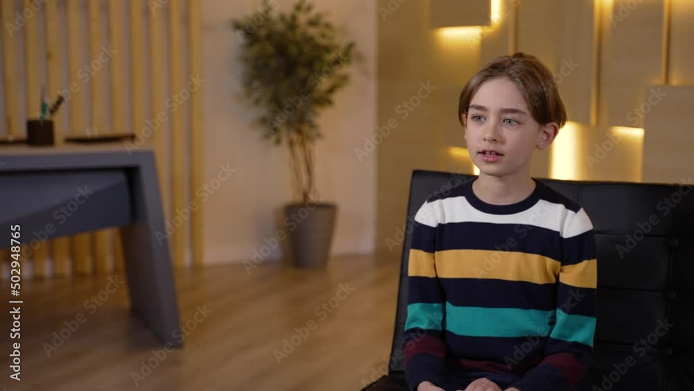 Close-up of adorable preteen boy sharing his problems on appointment with child psychologist. Preadolescent schoolboy communicating with therapist during psychotherapy consultation Close-up of adorable preteen boy sharing his problems on appointment with child psychologist. Preadolescent schoolboy communicating with therapist during psychotherapy consultation