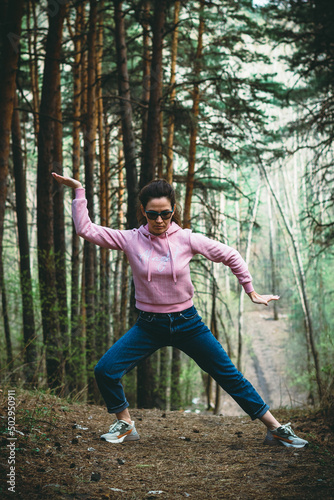 Woman practice Tai Chi Chuan in a park. Chinese management skill Qi's energy. solo outdoor activities. Social Distancing