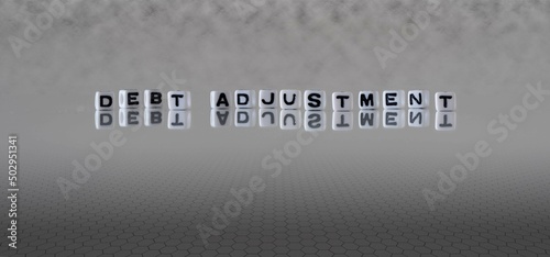 debt adjustment word or concept represented by black and white letter cubes on a grey horizon background stretching to infinity