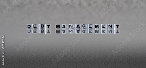 debt management word or concept represented by black and white letter cubes on a grey horizon background stretching to infinity