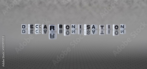 decarbonisation word or concept represented by black and white letter cubes on a grey horizon background stretching to infinity