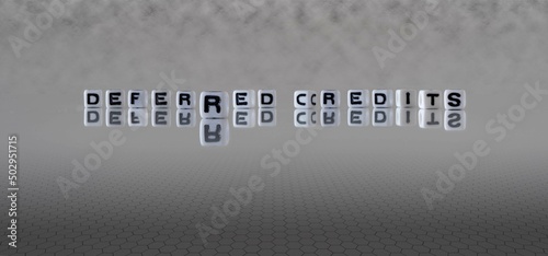 deferred credits word or concept represented by black and white letter cubes on a grey horizon background stretching to infinity