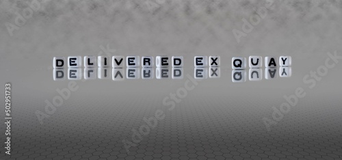 delivered ex quay word or concept represented by black and white letter cubes on a grey horizon background stretching to infinity