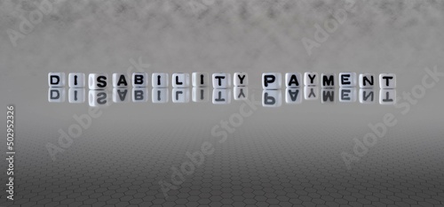 disability payment word or concept represented by black and white letter cubes on a grey horizon background stretching to infinity