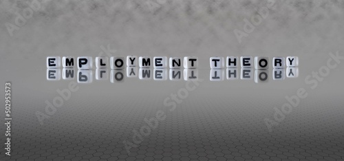 employment theory word or concept represented by black and white letter cubes on a grey horizon background stretching to infinity