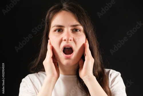 Photography A woman with an open mouth holds her cheeks with her hands, exercises for dysfun