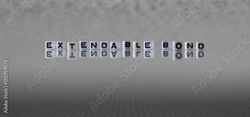 extendable bond word or concept represented by black and white letter cubes on a grey horizon background stretching to infinity