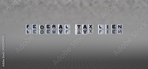 federal tax lien word or concept represented by black and white letter cubes on a grey horizon background stretching to infinity photo
