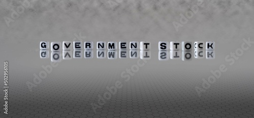 government stock word or concept represented by black and white letter cubes on a grey horizon background stretching to infinity