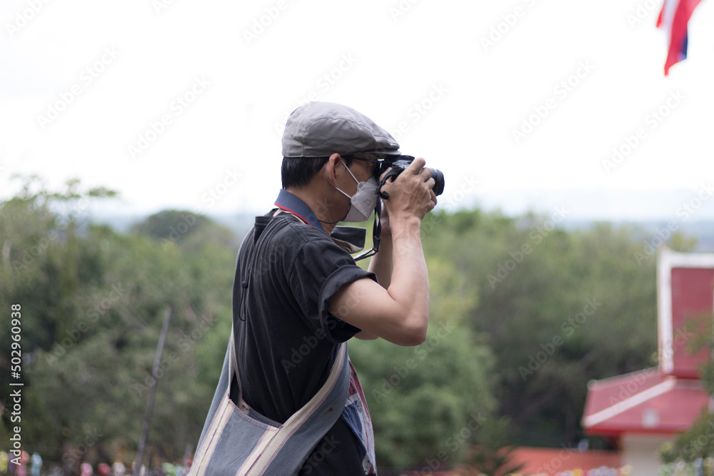 An adult is taking pictures with a camera in a tourist attraction with a stern expression. An adult is taking pictures with a camera in a tourist attraction with a stern expression.