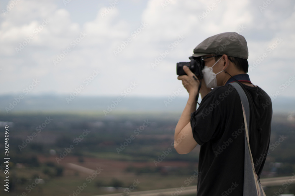 An adult is taking pictures with a camera in a tourist attraction with a stern expression. An adult is taking pictures with a camera in a tourist attraction with a stern expression.